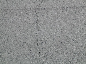 Close-up photo of a single low-severity crack.  The crack is tight and has no visible spalling.