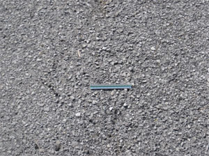 Close-up photo of a small area of asphalt pavement where the majority of the surface has missing aggregate.