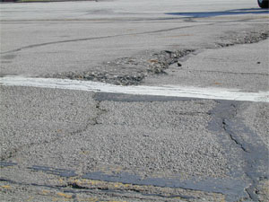 Overview photo showing a noticeable upward bulge in the pavement surface.