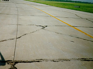 Overview photo showing a slab that is broken into four or five larger pieces.            The cracks that divide the pieces are low-severity cracks.
