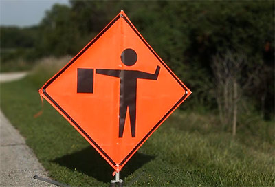 Flagger sign side of the road