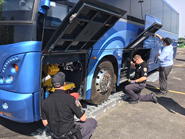 photo of enforcement officers inspecting a bus