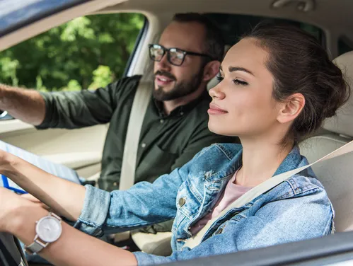 A young women in car taking a drive test.