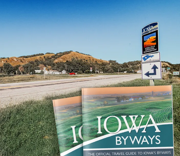 Byway road with sign and images of the current Byways Guide in the foreground