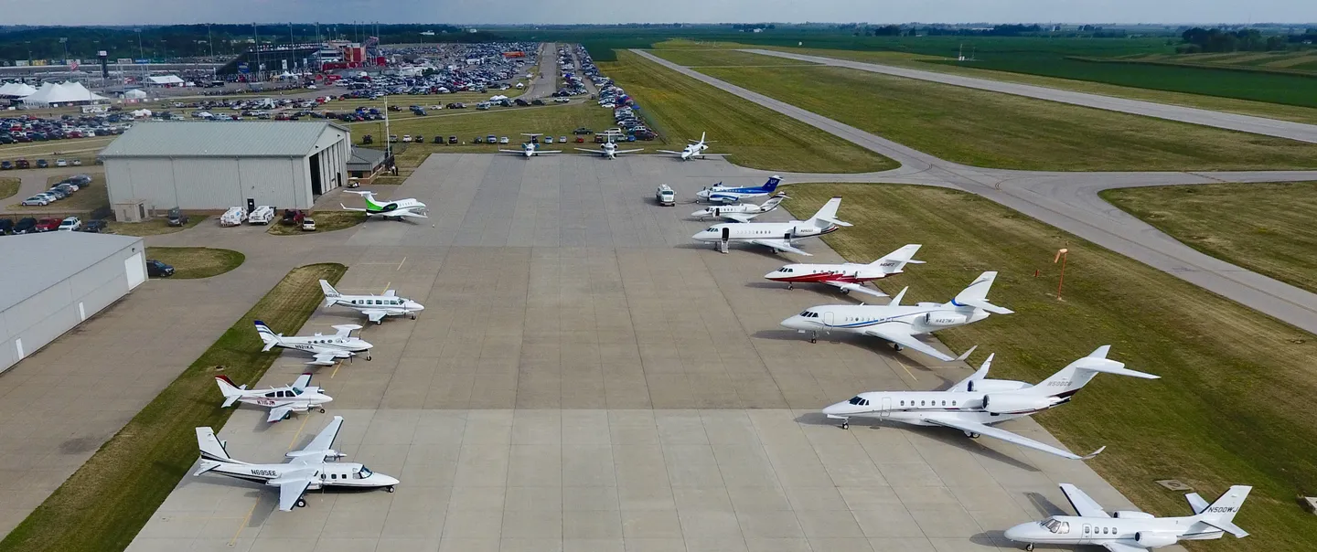 Planes aligned, facing each other, on a long stretch of pavement at an Iowa airport