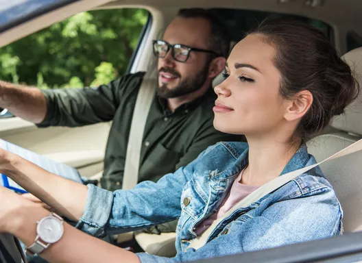 A young women in car taking a drive test.