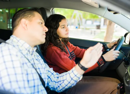 Teen driver taking driving instructions from adult