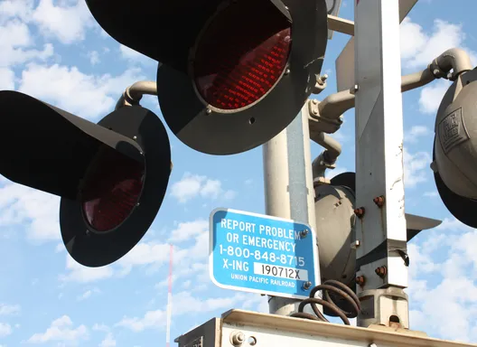 Blue sign posted at rail crossing