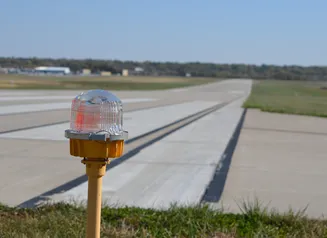 A blinking light at the end of an airplane runway
