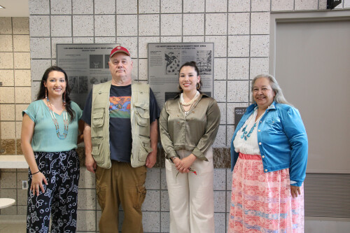 Four people standing inside the rest area, posing for the photo.