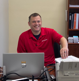 A person seated at a desk smiling
