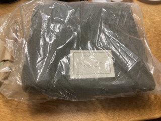 a folded grey blanket in a plastic bag