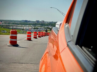 Orange cones placed to gradually taper two lanes on a road down to one lane.