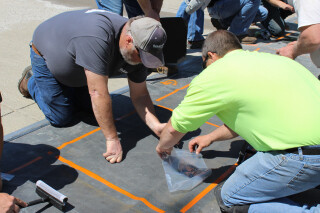 two people collecting and bagging salt from the test scatter grid area