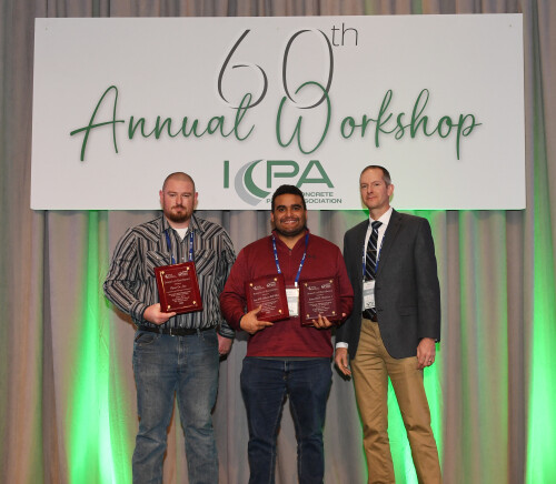 Three people on a stage accepting an award