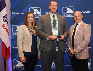 Three people standing together at an awards ceremony