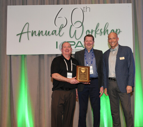 Three people standing on a stage, accepting awards