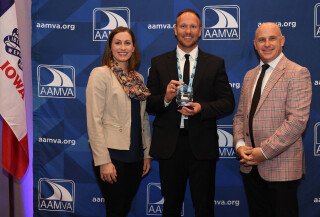Three people standing together at an awards ceremony