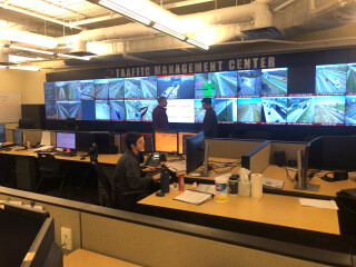 workers in the Iowa traffic management center near a wall of traffic camera views