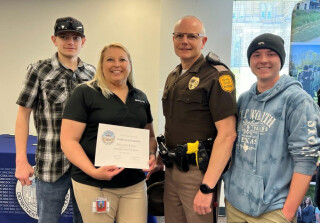 Michelle Kober receiving a certificate standing with 3 other people