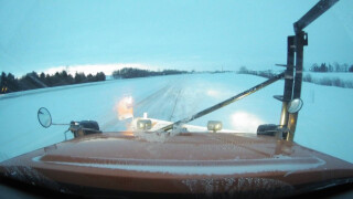view from a snowplow dash cam, showing the reach of the headlights