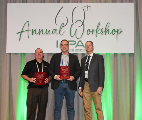 Three people standing on a stage accepting awards