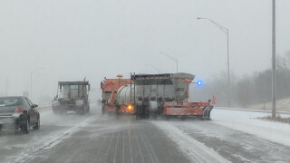 Photo of an Iowa DOT Towplow, being towed behind an Orange snowplow on a snowy highway.