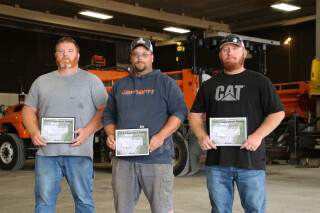 Photo of three people standing together with their awards