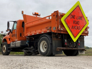 Back view of a large orange DOT maintenance truck