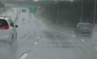 roadside view of a traffic moving on a wet highway