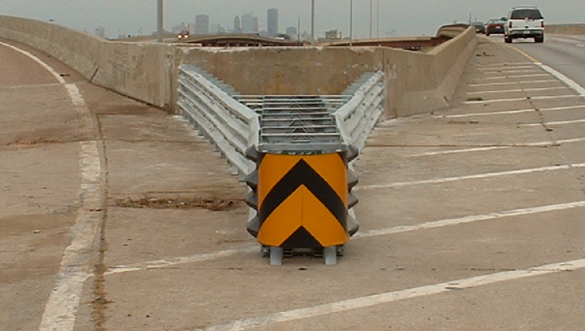 Crash cushion installed at a gore area between two concrete barriers.