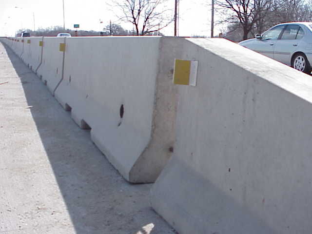 Temporary concrete barrier rail sections placed along a roadway.
