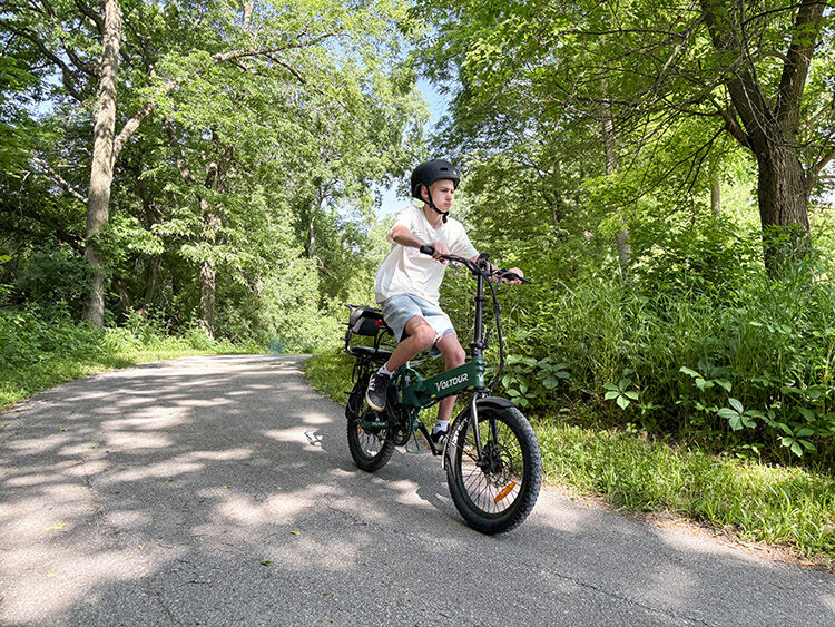Teen riding e-bike safely through park